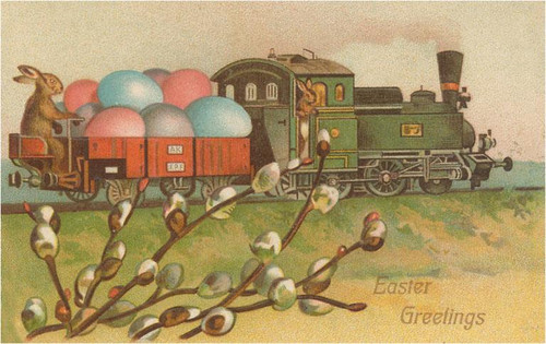 vintage easter postcard with green steam train carrying pastel eggs and a bunny riding on the back