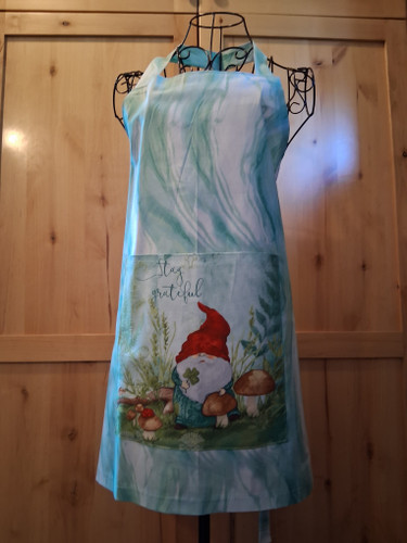Handmade turquoise apron with a square kindness‑themed gnome pocket and matching turquoise ties