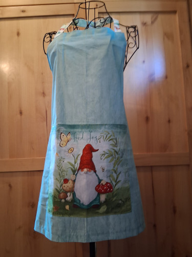 Handmade blue‑green apron with a 10.5‑inch square gnome pocket and coordinating gnome‑pattern neck loop and waist ties