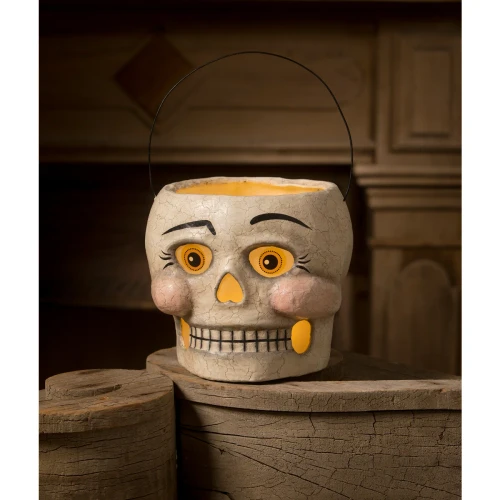 Vintage paper mâché skull bucket with painted features and glowing vellum eyes.