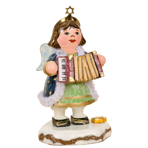 angel figurine playing accordion with gift on snowy base