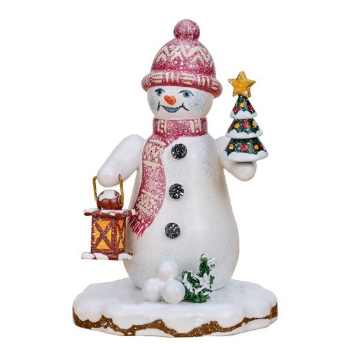 snowman figurine holding fir tree and lantern on snowy base