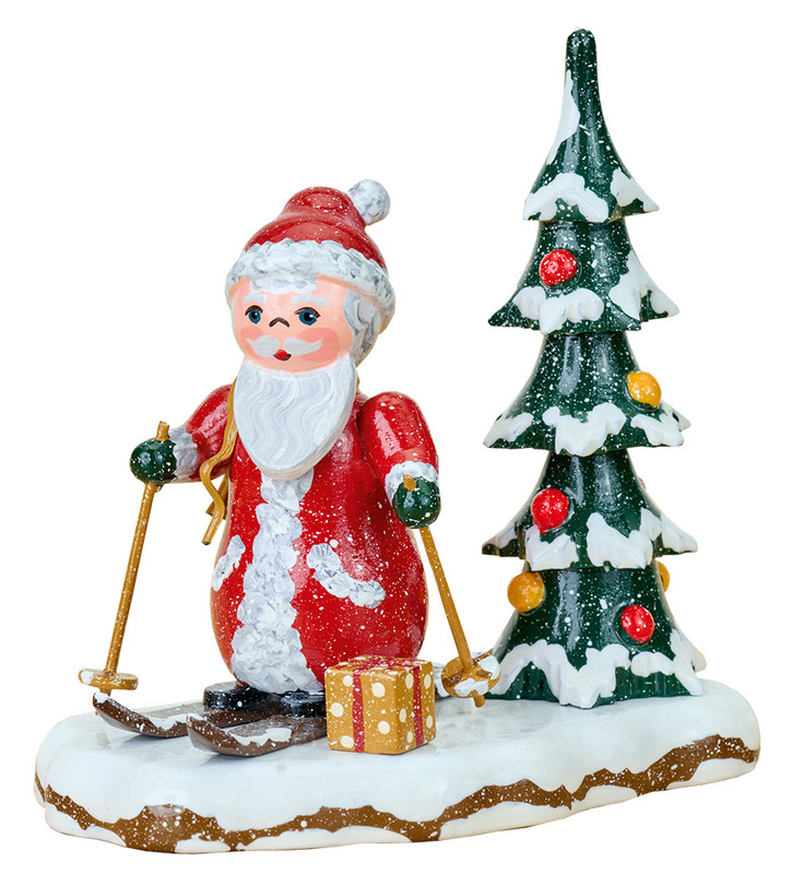 santa skiing with decorated tree and gift on snowy base