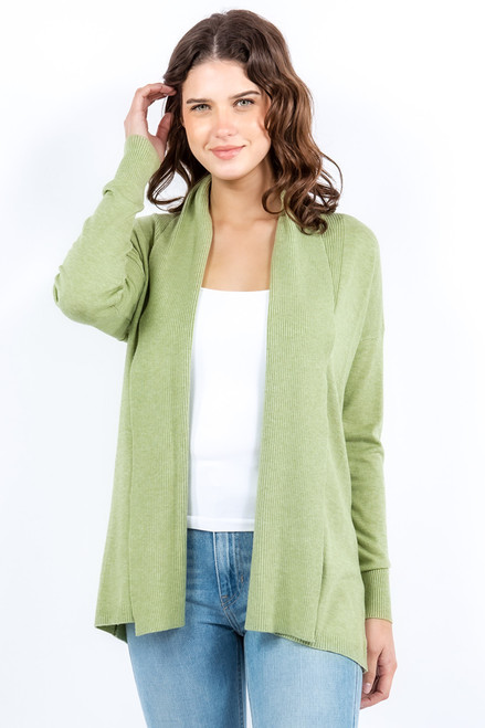 A woman is pictured wearing a fresh heather apple green cardigan that captures the essence of spring-summer with its delicate yet lively color. The cardigan's ultra-soft lightweight material, open front design, wide ribbed details, drop shoulders, and snug ribbed hem and cuffs provide both style and comfort.