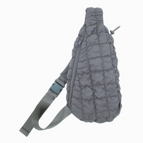 A modern, lightly quilted sling bag in a neutral gray tone featuring a full zip closure. The bag is designed with a textured exterior, an adjustable nylon strap with a buckle, and is approximately 14 inches high, 8 inches wide, and 4 inches deep. It has a fully lined interior with an inside zip pocket and an open pocket, made from 100% polyester