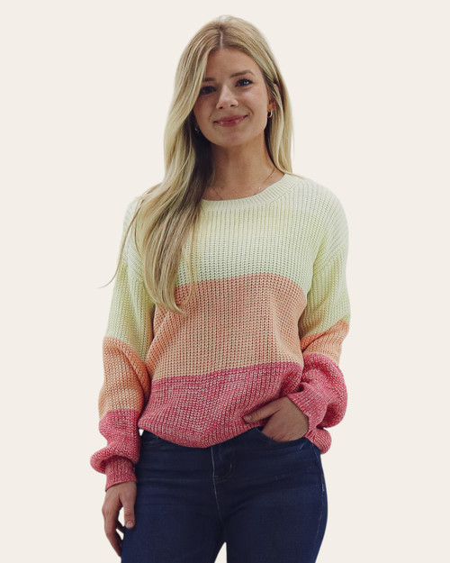 Front view of a woman wearing the Sunny Springs color-block knit sweater in yellow, peach, and pink with dark denim.