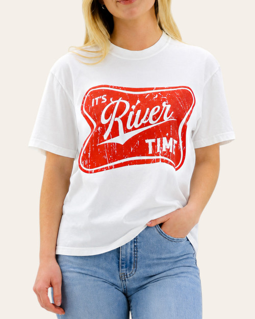 Front view of the white It's RIVER Time graphic tee featuring a vintage red graphic, modeled with light blue denim.