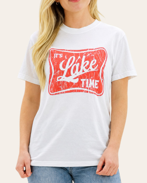 Woman wearing a white It's Lake Time graphic tee with a distressed red retro design, available at our Roscoe, SD boutique.