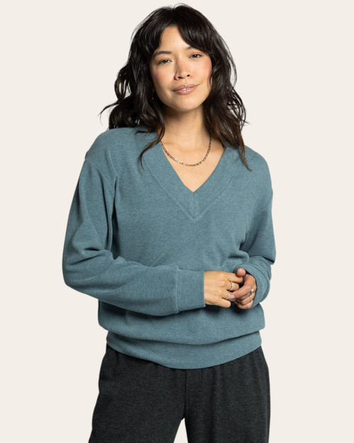Front view of a woman in a spruce heather V-neck long sleeve knit top, styled for casual comfort and cozy everyday wear.