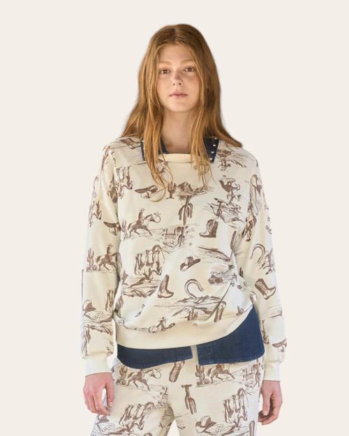 Front view of a western-themed cream lounge sweatshirt with brown cowboy illustrations, worn casually for cozy fall comfort.