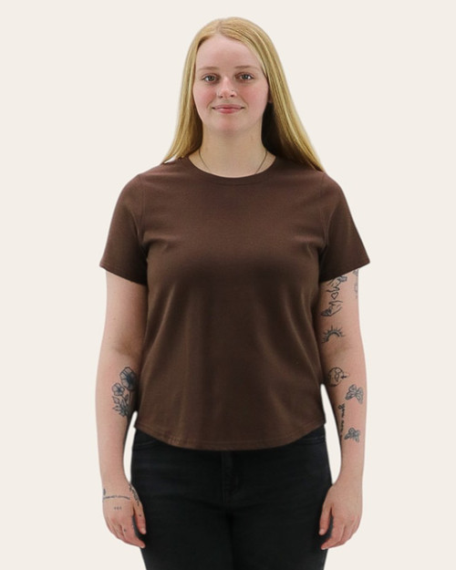 Front view of a woman wearing a brown short sleeve cotton tee with a relaxed fit and slightly curved hemline.