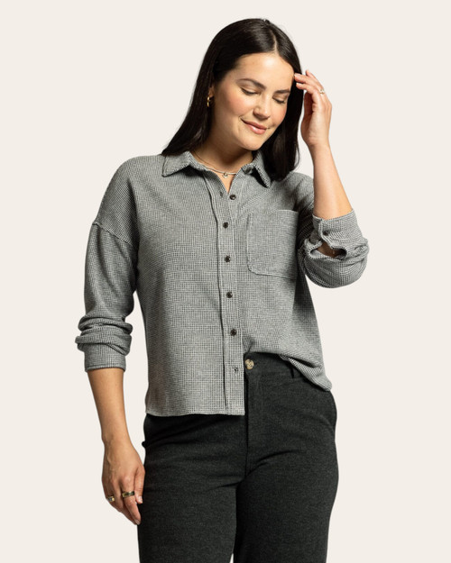 Front view of a woman in a grey waffle-knit button shirt with front pocket, styled with casual dark pants. Front view of a woman in a grey waffle-knit button shirt with front pocket, styled with casual dark pants.