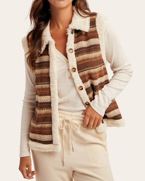 Woman modeling a cozy brown and cream patterned button-down sherpa vest from our Roscoe, SD boutique.