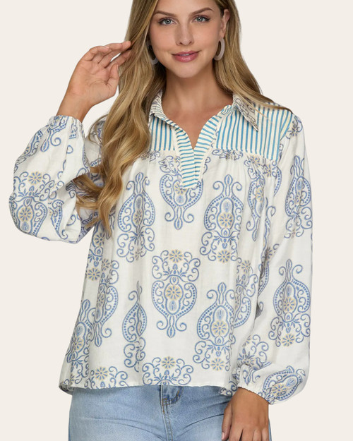 Front view of the Cassidy Printed Blouse featuring a light blue medallion print and striped split neckline.