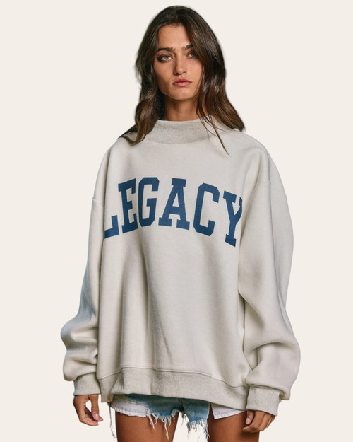 Front view of a heather grey oversized sweatshirt featuring navy LEGACY text, available at Trendy Threads Roscoe.