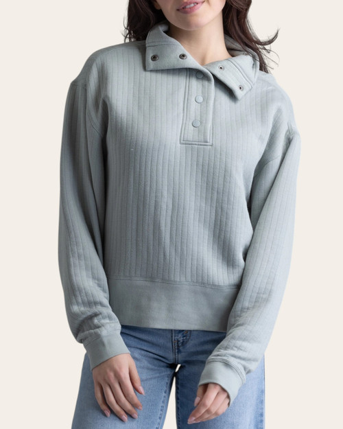 Front view of the Lucia vertical quilted pullover in aqua grey styled with light wash denim.