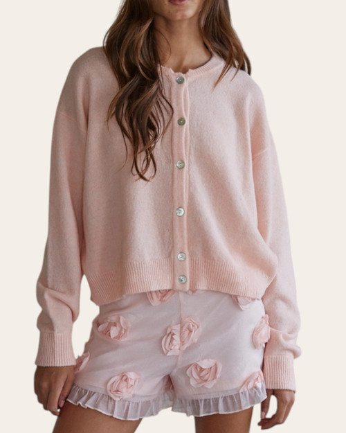 Front view of the Layla light pink knit cardigan with delicate button details, styled for spring.