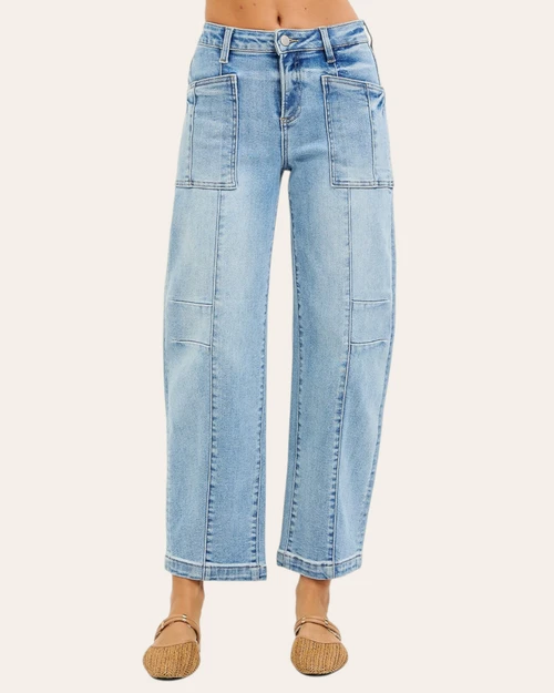 Front view of woman wearing Risen light wash slouchy barrel jeans with patch pockets and front seam details.