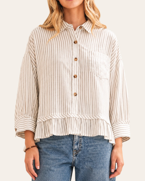 Woman wearing a relaxed fit striped ruffle hem top with button front closure and 3/4 sleeves.