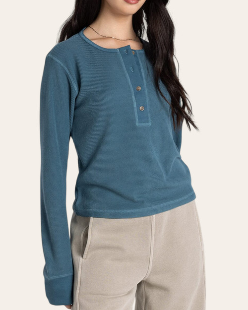 Close up of the Thread and Supply Tana Top in mallard blue featuring a lightly ribbed fabric and rounded button-down neckline.