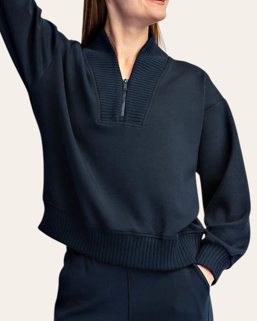 Woman modeling the front of the teal and navy Kennedy Quarter Zip Scuba Pullover