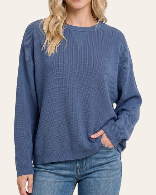 Front view of model wearing the denim blue Carmine Crewneck Sweater featuring a classic crew neck and drop shoulders.
