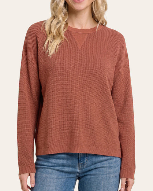 Model wearing the Carmine Crewneck Sweater - Rust, front view with a crew neckline, textured fabric and long sleeves.