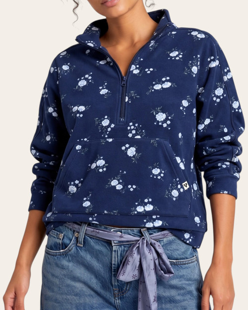 Eclipse Dainty Floral Fleece Pullover modeled from the front, showing navy fabric with pale flowers, a zip collar and pouch pocket.