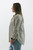 Side profile of a relaxed-fit striped shirt with button-up front and distressed hem, a Trendy Threads Boutique new arrival for a fresh spring wardrobe.