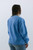 The back view of a Trendy Threads Boutique's new spring collection item, featuring a pastel blue sweatshirt that offers a blend of cozy comfort and laid-back style, ideal for cool spring days.
