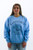 A young woman models a light blue crewneck sweatshirt with 'Nantucket Island Massachusetts' and a sailboat graphic, available at Trendy Threads Boutique for spring. The casual, comfortable design is perfect for a relaxed, stylish look this season.