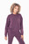 A woman with curly hair models the Twilight sweatshirt in a rich dark plum color, radiating a blend of athletic appeal and everyday chic. The sweatshirt boasts ultra-soft fabric, side zipper accents, a zippered chest pocket, and nylon inserts on the sleeves, all designed to deliver a relaxed yet fashionable fit.
