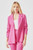 A woman models the Just Feels Right Blazer, crafted from a soft, stretchy knit fabric in a vibrant hot pink shade. The blazer boasts a slimming structure with a comfortable 4-way stretch, 3/4 length ruched sleeves, functional side pockets, and a timeless notched lapel open front design. It's styled with a matching hot pink pant, creating a monochromatic and chic outfit.