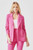 The same woman is shown in a different pose, highlighting the Just Feels Right Blazer's versatile style that can be dressed up or down. The jacket's tailored fit and functional details, combined with its striking hot pink color, make it a perfect addition for a fashion-forward look, paired here with coordinating pants for a cohesive, on-trend ensemble for the season. The blazer fits true to size, ensuring a flattering appearance.