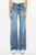 A person stands showcasing the front view of the Allison Jeans by KanCan, featuring a high-rise waist and a medium wash. The soft, stretch denim material hugs down to the knees where it flares into a tailored hem, paired with white sneakers for a casual look.