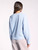 Rear view of the Elliot Pullover by Thread & Supply, showing the banded hem and the plush texture of the fabric. The woman's relaxed posture emphasizes the pullover's comfortable design.