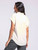 Back view of the woman in the Ambrose Top, highlighting the frayed hemline and the loose, comfortable fit against the casual patterned pants.