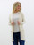 Side view of the Always Faithful Cardigan, showcasing its mid-thigh length and ribbed hem detail, styled with blue jeans.