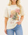 Front view of the Chasing Dreams graphic tee featuring a vintage-inspired floral and butterfly design, modeled with light wash jeans.