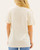 Back view of the soft cream Chasing Dreams graphic t-shirt worn by a blonde model.