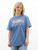 Woman wearing a soft blue graphic T-shirt with hand-drawn floral design on the front, styled with light wash jeans.