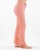 Side view of mid-rise peach pink jeans featuring a vintage straight-leg cut and raw hem detail, shown on a barefoot model.