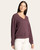 Side front view of a woman in a wine heather v-neck pullover top with long sleeves and white denim pants
