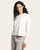 Side view of a woman in a heather oatmeal knit long sleeve top paired with textured beige joggers

