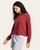 Side profile of a woman in a crimson long sleeve knit top paired with light grey drawstring shorts