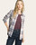 Woman modeling an open Cassian plaid flannel shirt over a burgundy top with dark denim jeans.