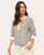 Woman wearing a casual navy and white striped henley top with cream cuffed sleeves and pocketed jogger pants