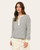 Front view of a woman wearing a navy and white striped henley-style top with long sleeves and cream joggers