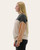 Side profile of a woman in a long sleeve ribbed top featuring colorblock design with dropped shoulders.
