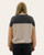 Back view of a woman wearing a colorblock ribbed top with black, beige, and rust panels and relaxed fit.
